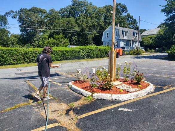 Harry Corrie watering the plants and flowers in the parking lot of the VFW Hall. One of his roles as he helps keep the grounds looking nice.