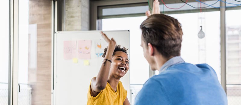 Photo of a young person and adult giving each other a high five