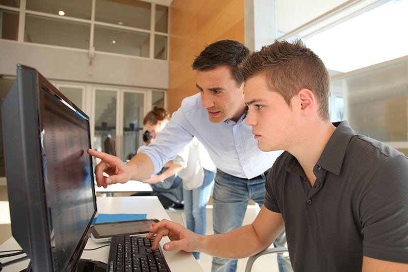 Photo of a student and adult looking at a computer